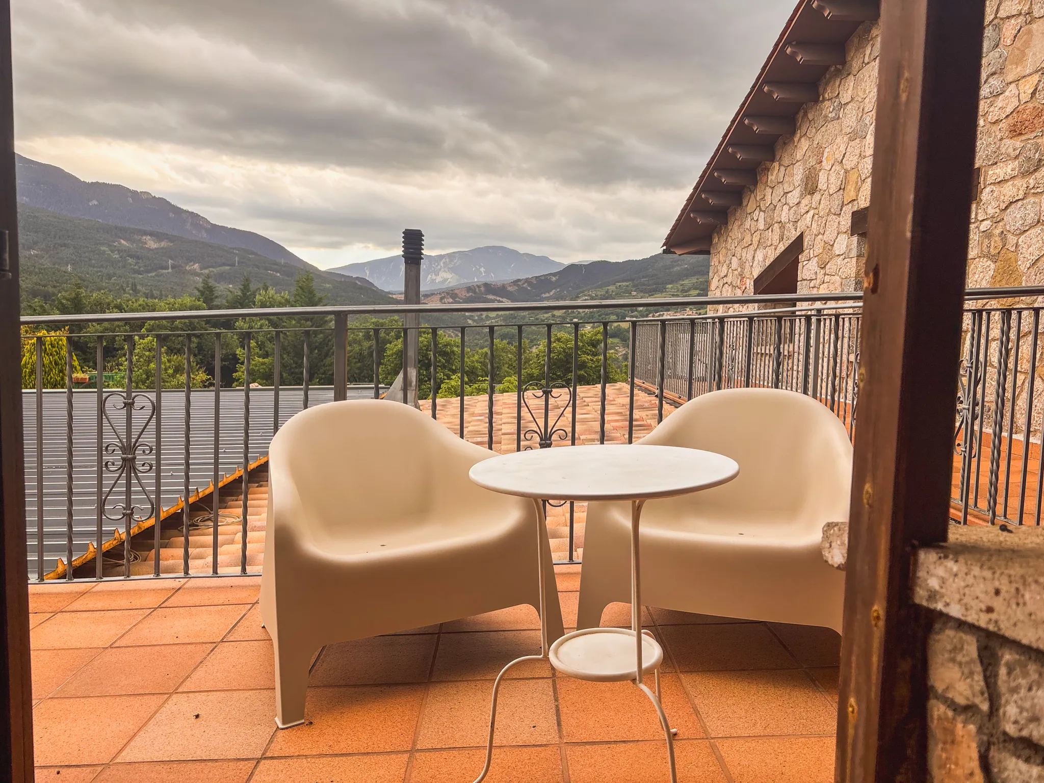 Dues butaques i una taula petita en una terrassa privada amb vistes a la muntanya