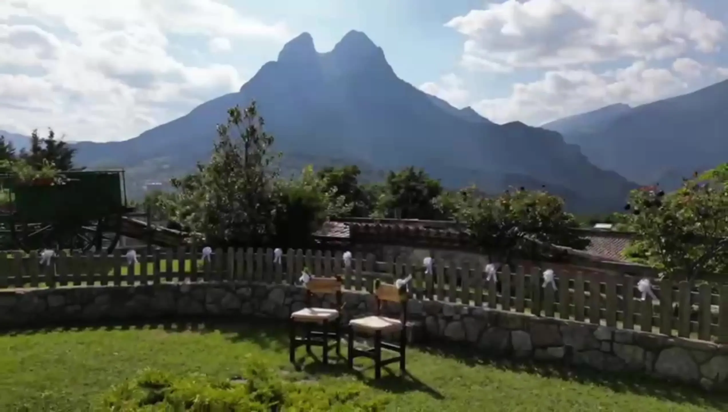 Dues cadires de fusta al jardí de la casa, davant del Pedraforca